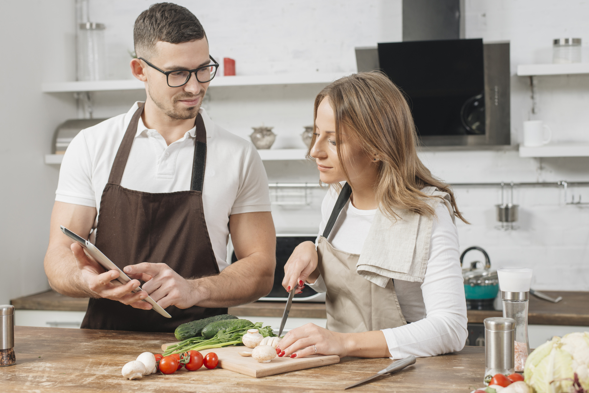 Chef guiding a home cook in a small kitchen